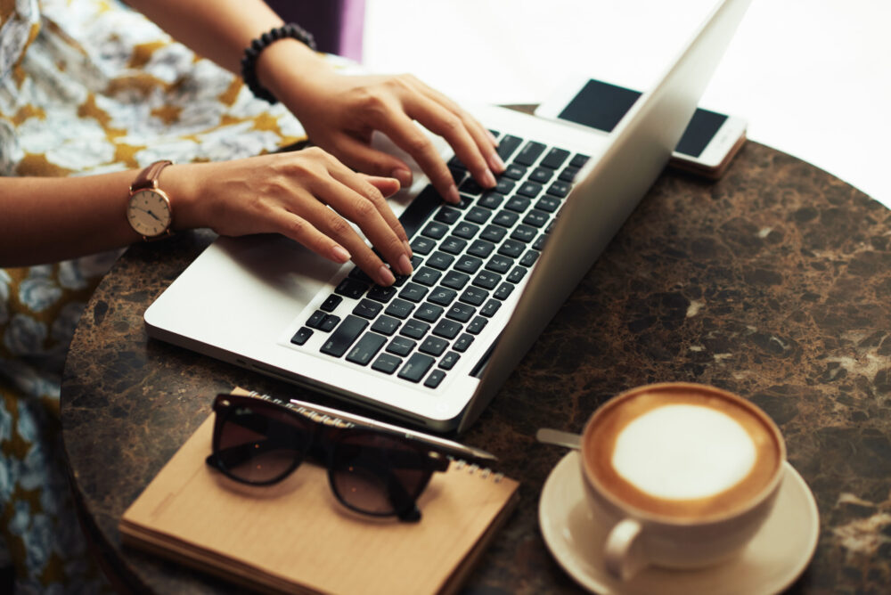 Hands of woman using her laptop when resting in cafe